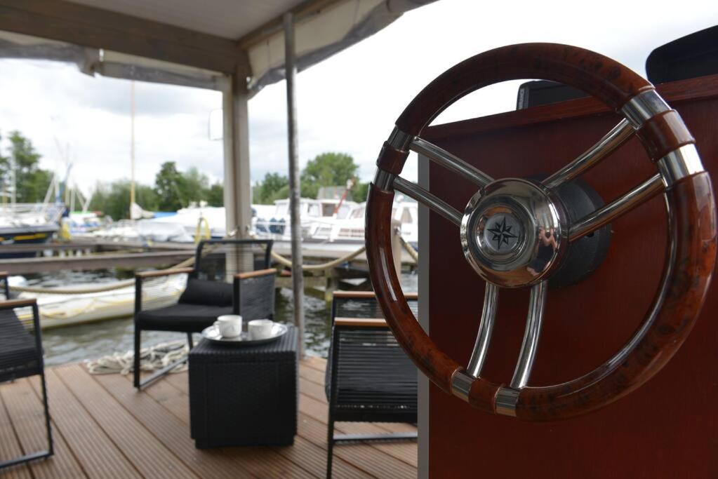 a wooden steering wheel on a boat in a marina at Hausboot NautikHus auf der Havel in Kolonie Zern
