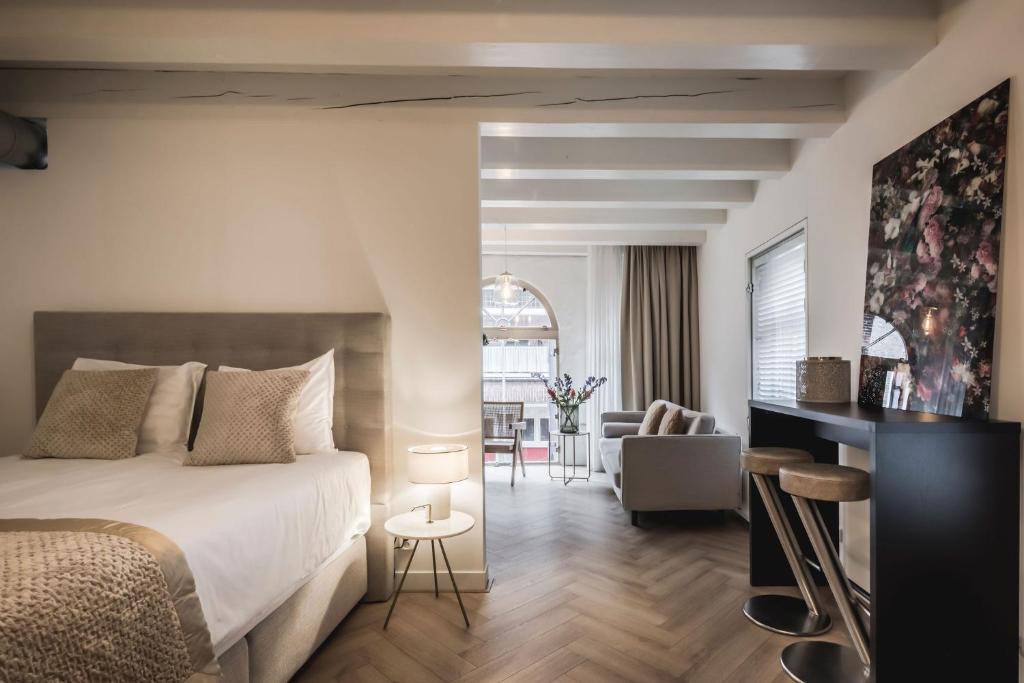Le Bon'Apart Suites في خورينخيم: غرفة نوم مع سرير وغرفة معيشة