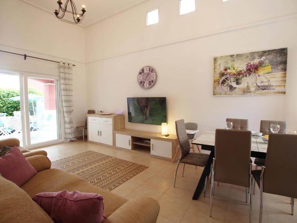 a living room with a table and a dining room at Villa Amyali by Rentalole Mar Menor Golf Resort in Torre-Pacheco