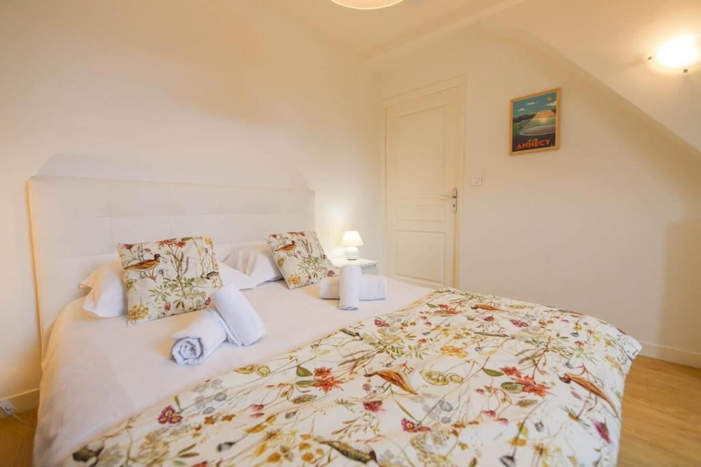 une chambre avec un grand lit avec un couvre-lit fleuri dans l'établissement Le Sommeiller - hyper centre avec garage, à Annecy