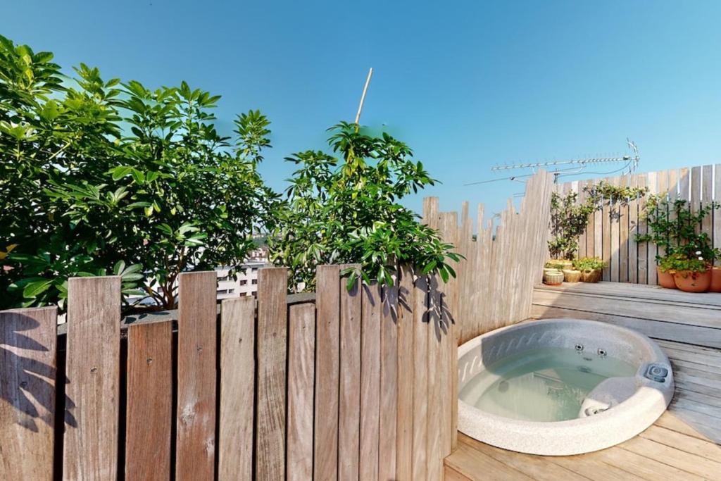 a wooden fence with a bath tub in front of a fence at Des Bulles en rooftop in Annecy