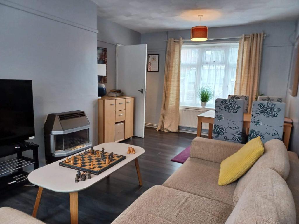 a living room with a couch and a chess board at Poynters House - Huku Kwetu Luton & Dunstable - Spacious 2 Bedroom- Suitable & Affordable Group Accommodation - Business Travellers in Luton