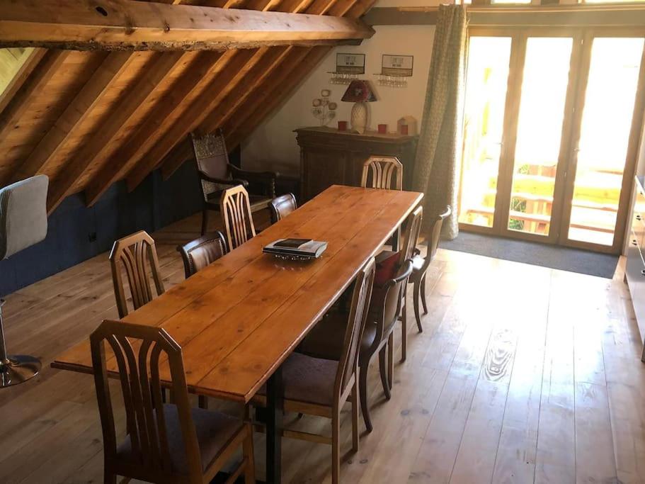 a wooden table and chairs in a room at Chez Pierrette et Eugène Prix nuitée&#47;10 personne in Le Lautaret