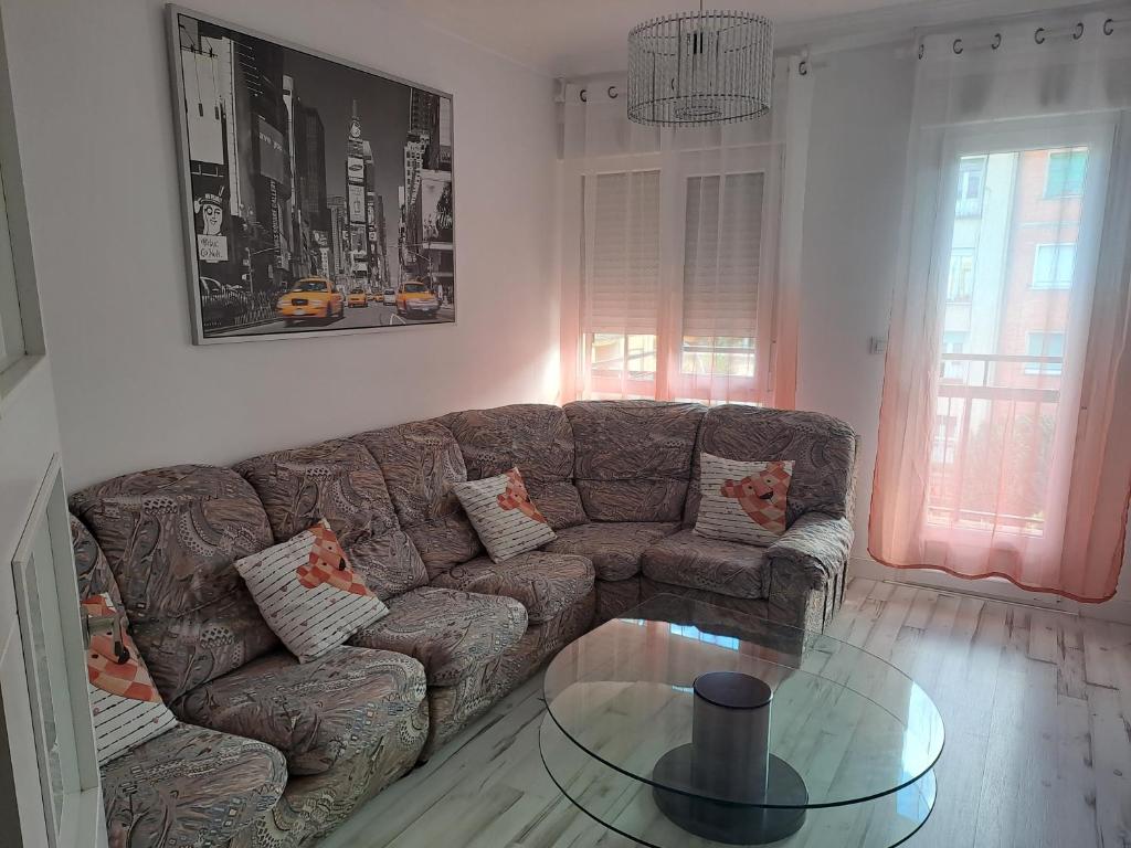 a living room with a couch and a glass table at Apartamentos El Conde in Santo Domingo de la Calzada