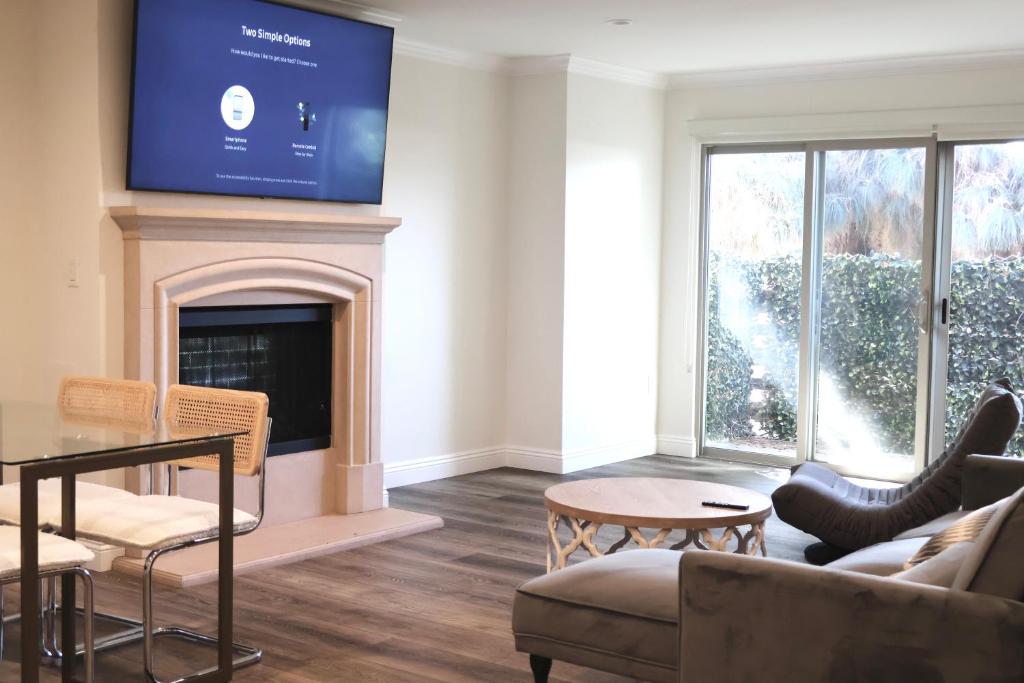 a living room with a tv above a fireplace at Best location and value in Pasadena