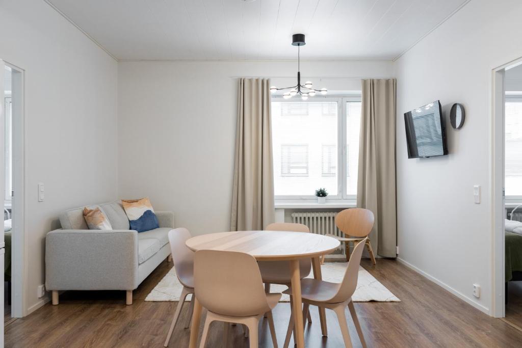 ein Wohnzimmer mit Tisch und Couch in der Unterkunft Forenom Serviced Apartments Pori Antinkatu in Pori