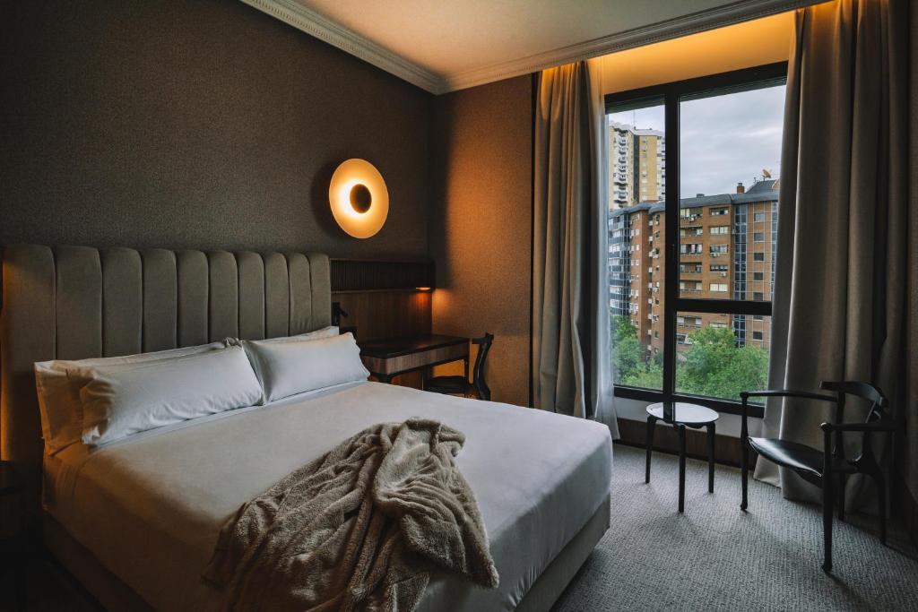 a bedroom with a bed and a large window at Hotel Pinar Plaza in Madrid