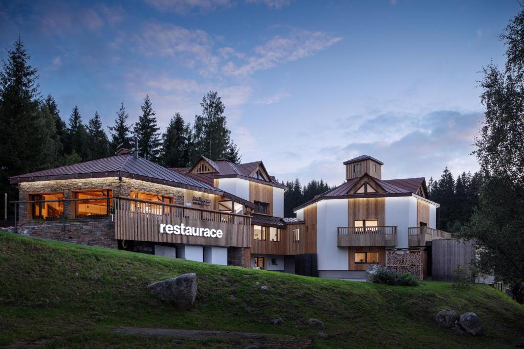 a large house on top of a hill at Ski & Spa hotel BELLEVUE in Harrachov