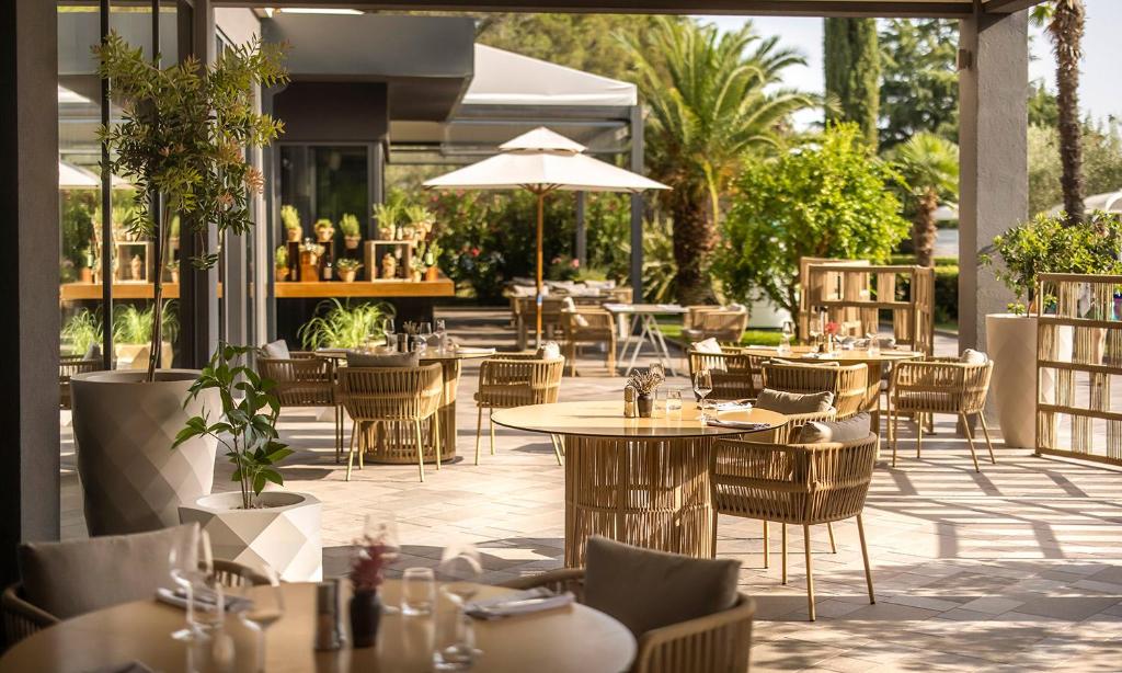 an outdoor dining area with tables and chairs at Aminess Vival Maestral Hotel in Novigrad Istria