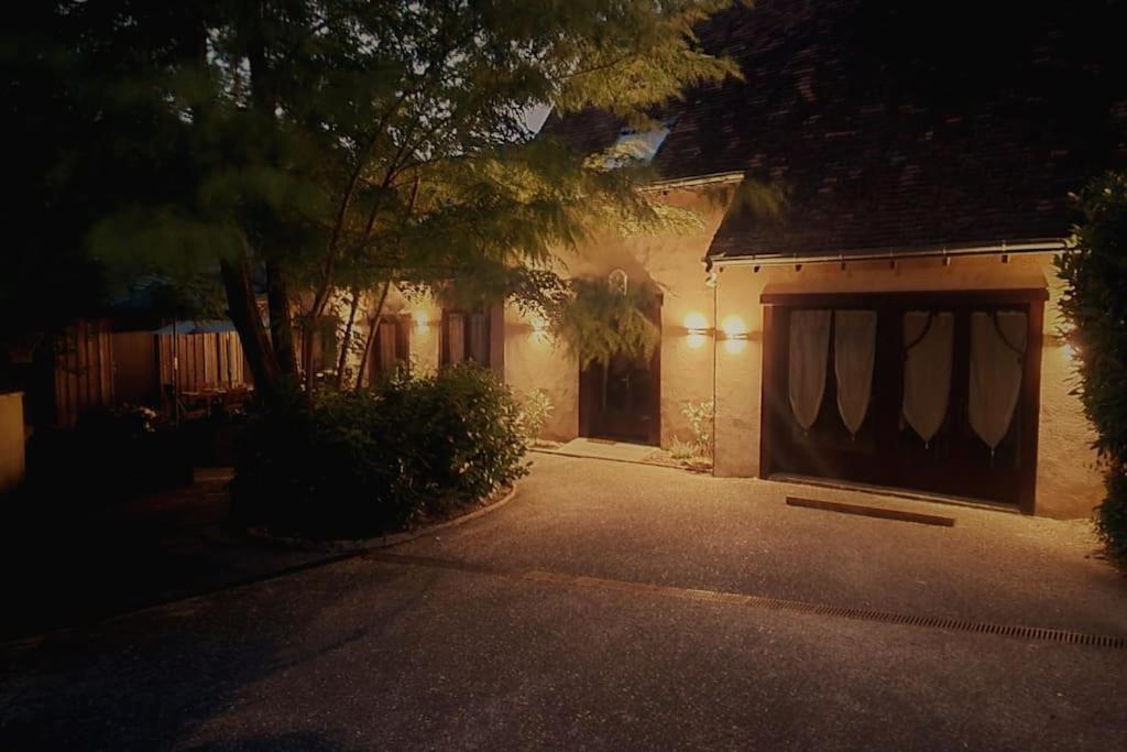 una casa con un garaje por la noche con luces encendidas en Grand Gîte - Le Saint-Chrirtophe, en Châteauroux