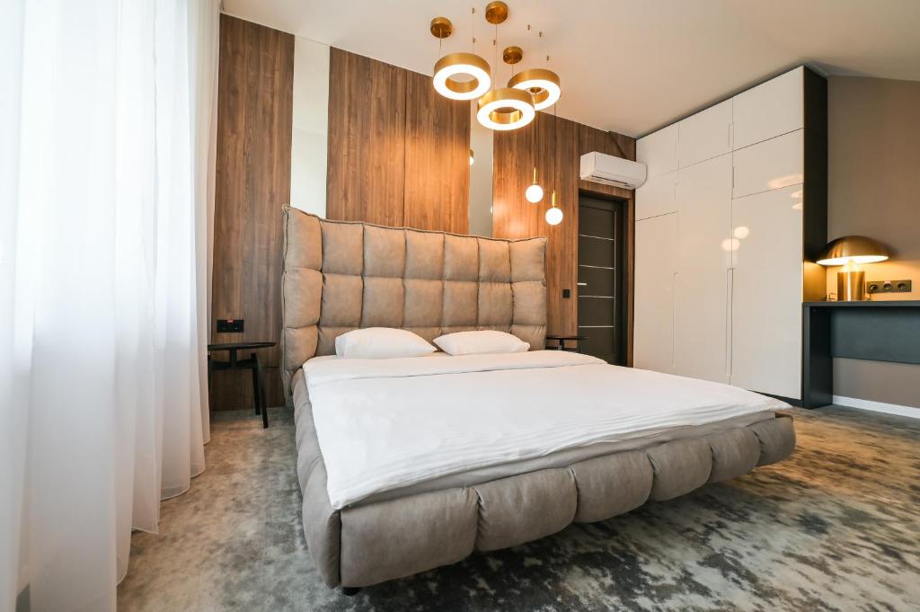 ein Schlafzimmer mit einem großen weißen Bett und einem Kronleuchter in der Unterkunft Садиба на Кодимі 