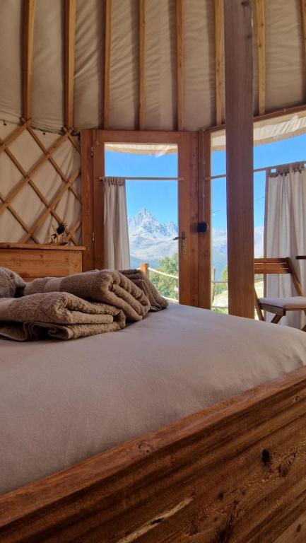 a bed in a room with a view of a mountain at MonvisoRelax in Ostana