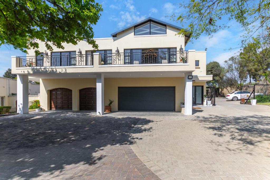 a large white house with a large garage at KwaMagogo Villa, Chartwell in Johannesburg