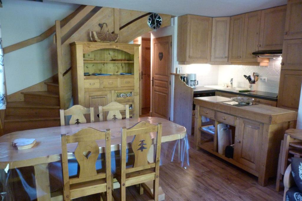uma cozinha com uma mesa de madeira e uma bancada em Appartement chaleureux, 8 personnes, 3 chambres - COEUR12 em Beaufort