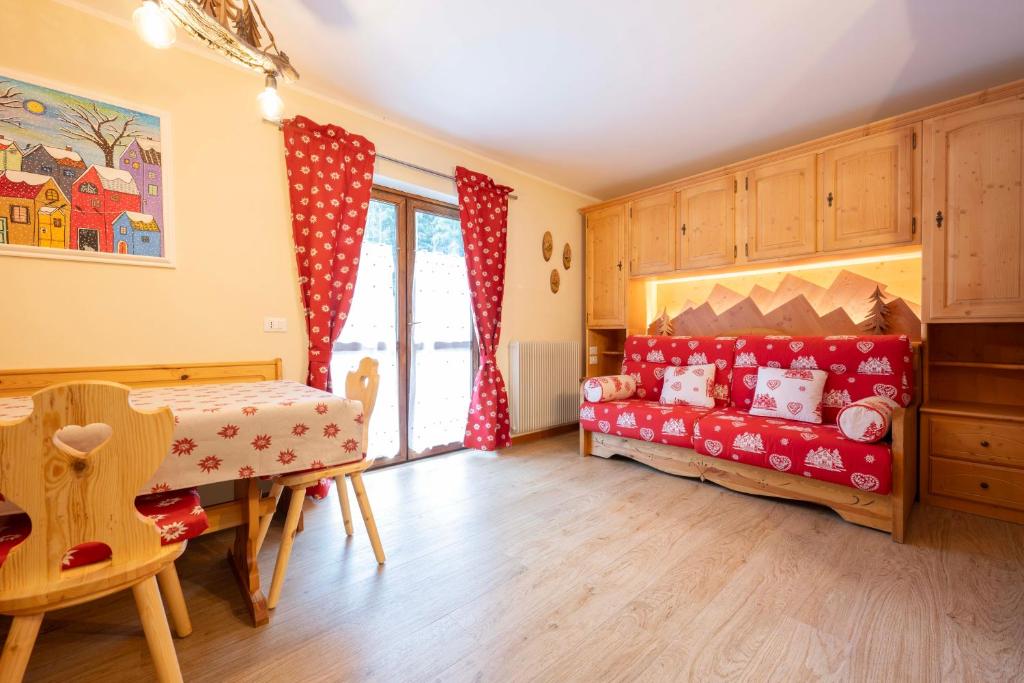 卡納澤伊的住宿－Cesa Ariale，一间儿童间,配有红色的沙发和桌子