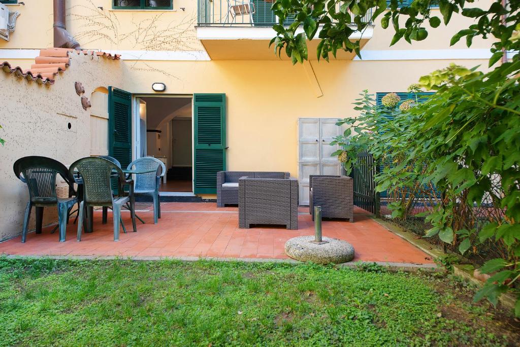 a patio with chairs and tables in a yard at Beach Paradise- Luigi 16 in Levanto