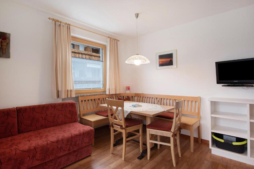 - un salon avec une table et un canapé rouge dans l'établissement Hilber App Furchetta Small, à Villnoss