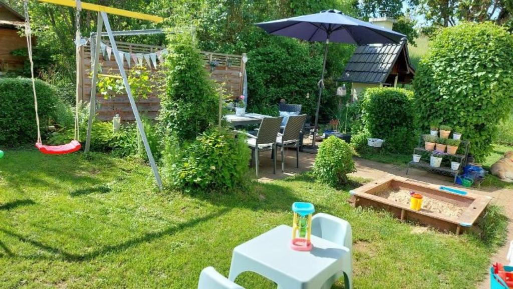 a small backyard with a table and an umbrella at Haus Elfriede in Müllheim