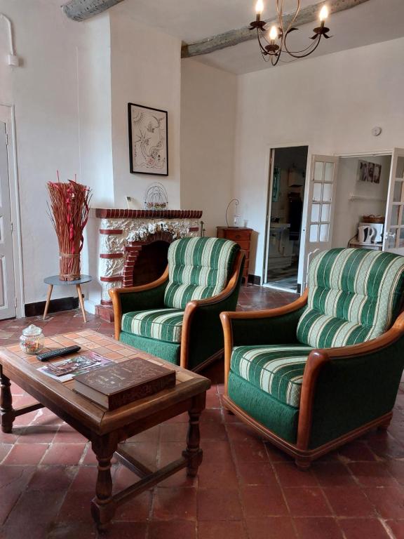a living room with two chairs and a coffee table at La Quiétude in Cotignac