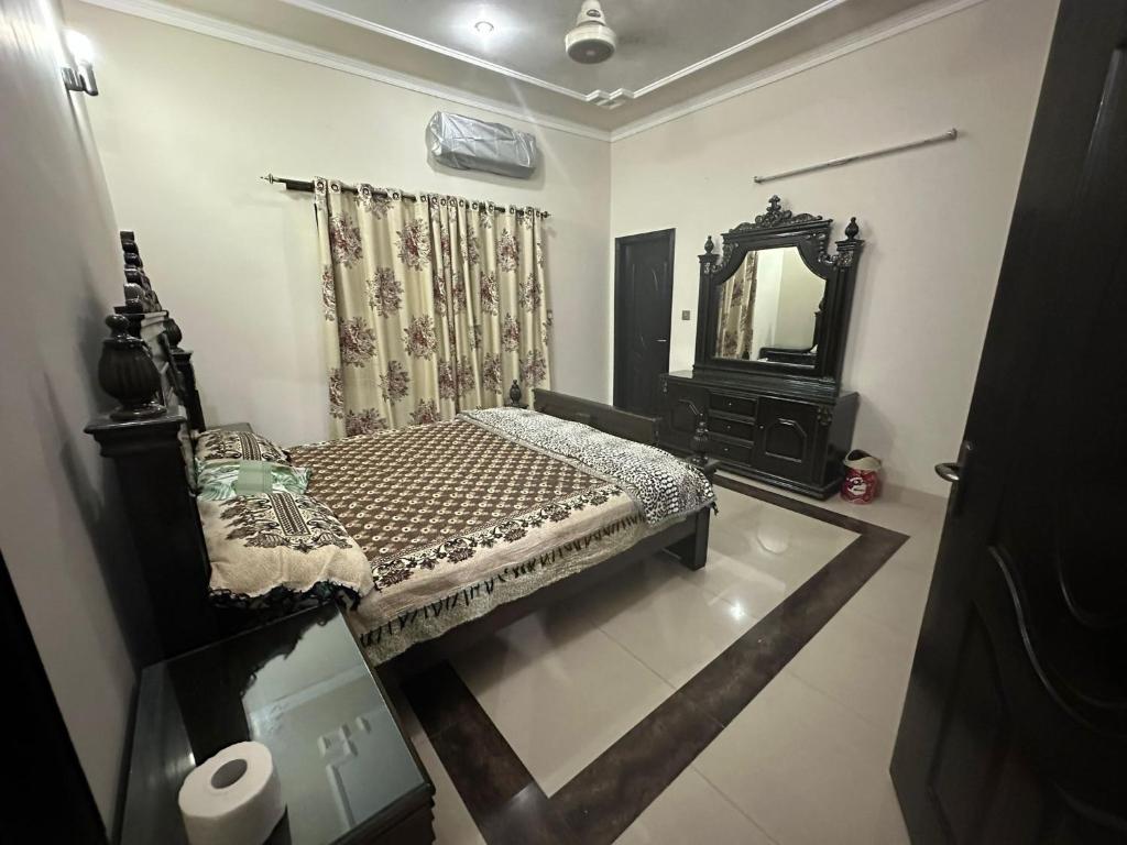 Bahria Town - 10 Marla 2 Bed rooms Portion for families only في لاهور: غرفة نوم صغيرة مع سرير ومرآة