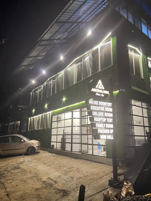 een gebouw waar 's nachts een bord voor staat bij AROMA INN in Kalpatta
