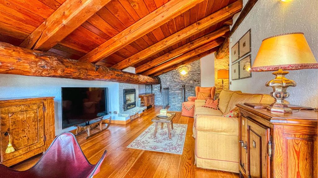 a living room with a couch and a tv at Appartamento Jouvenceaux 40 - Affitti Brevi Italia in Sauze dʼOulx