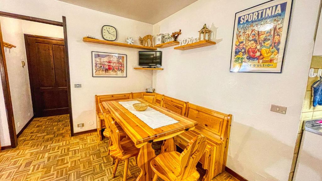 uma sala de jantar com uma mesa de madeira e cadeiras em Appartamento Montana - Affitti Brevi Italia em Sauze dʼOulx