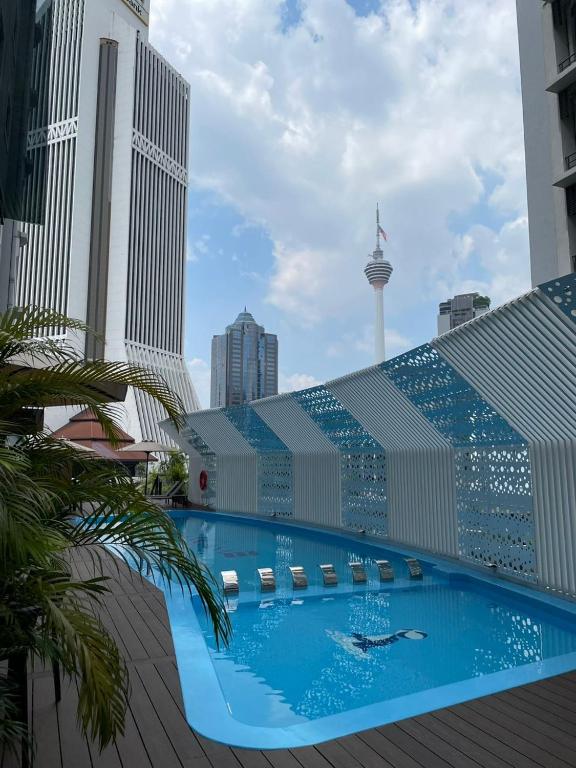 a large building with a swimming pool in the city at AnCasa Hotel Kuala Lumpur, Chinatown in Kuala Lumpur