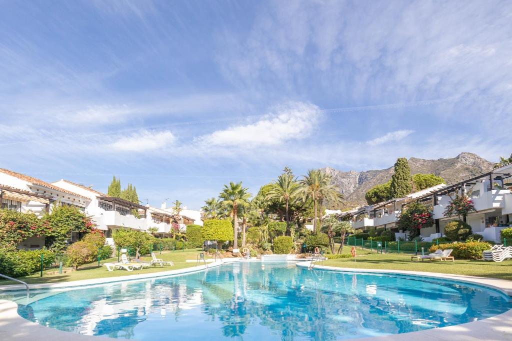 een zwembad in een resort met bergen op de achtergrond bij Apartamento Viveros Marbella in Marbella