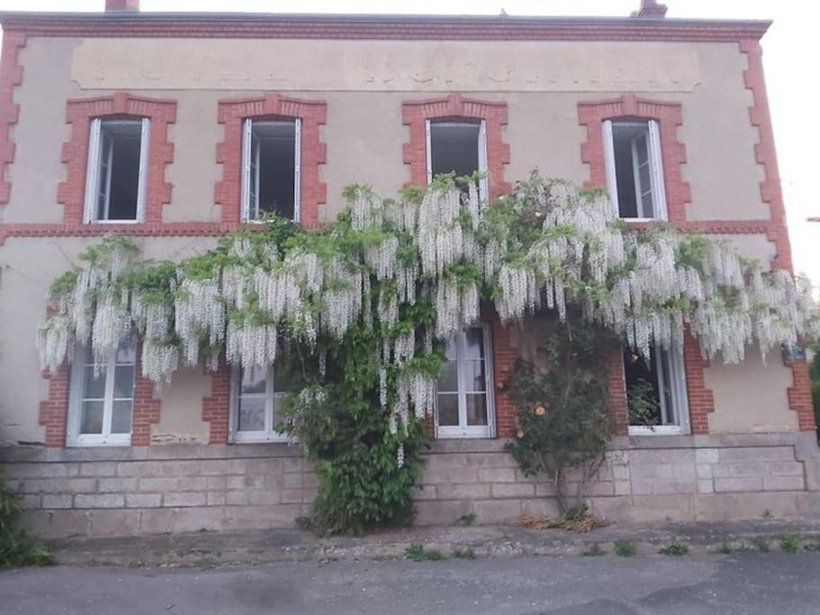 a house with white plants on the side of it at les glycines in Saint-Marien
