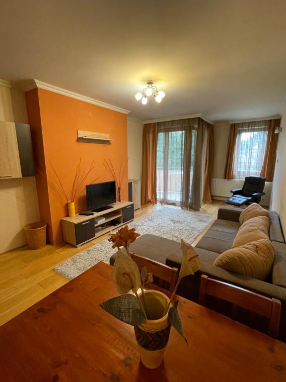 a living room with a couch and a tv at IK Apartment in Debrecen