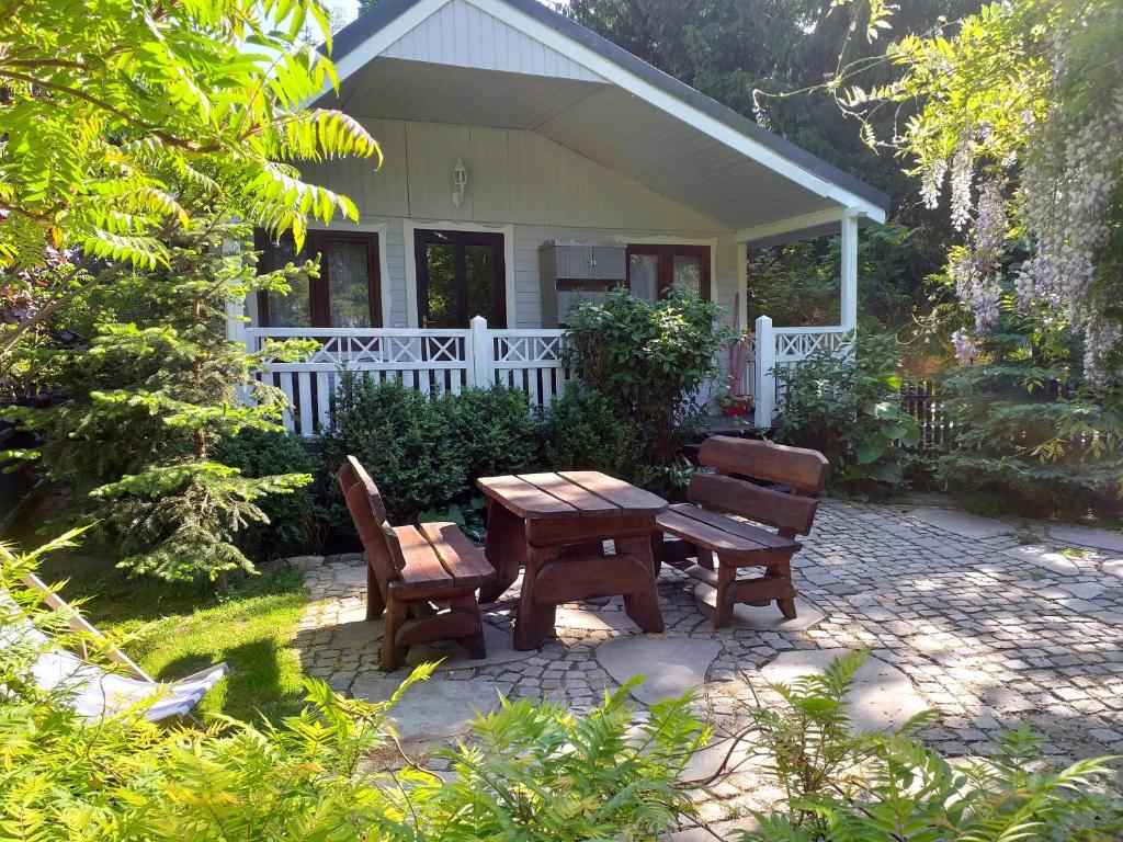 a picnic table and two chairs in front of a house at Pogodny- domek letniskowy Ośrodek Gałkowo noclegi w Stegnie in Stegna