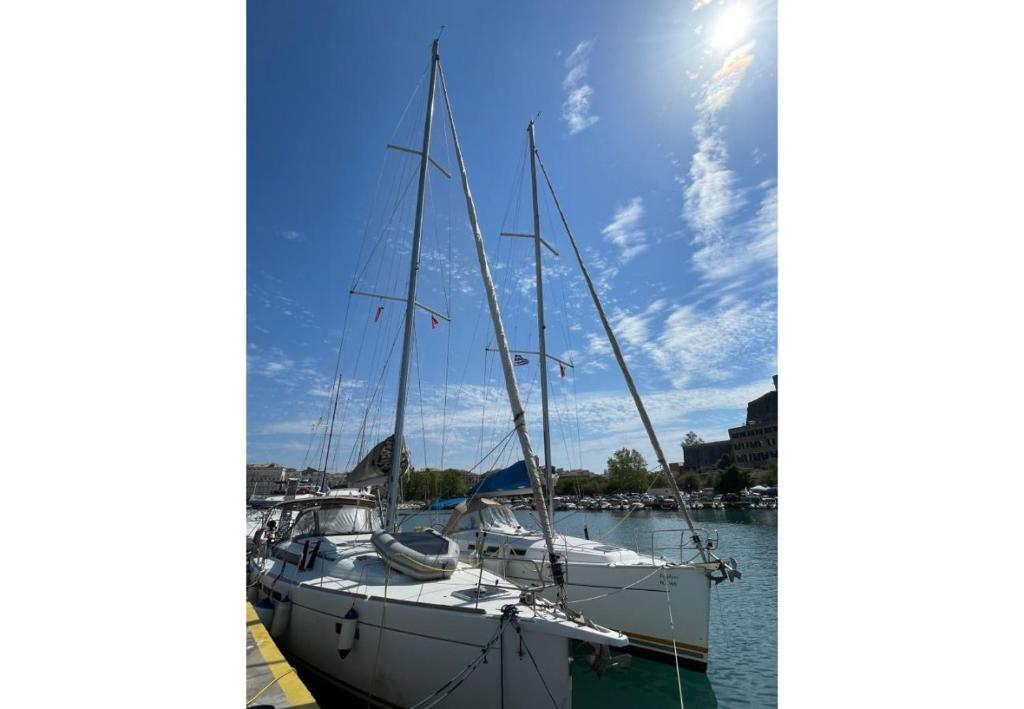 Zwei Boote sind in einem Hafen am Wasser angedockt. in der Unterkunft Oceanis 31037i in Korfu-Stadt