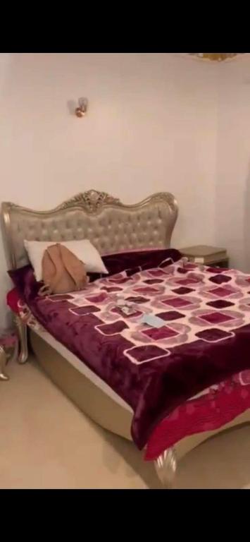 1 dormitorio con 1 cama con edredón morado y blanco en Poseidon Luxury Apartments, en Hurghada