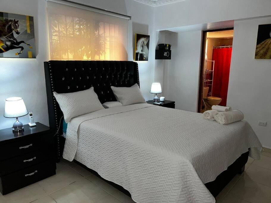 1 dormitorio con 1 cama grande y 2 lámparas en Apartamento entero Tu Nido De Amor 2 Santo Domingo oeste, en Santo Domingo