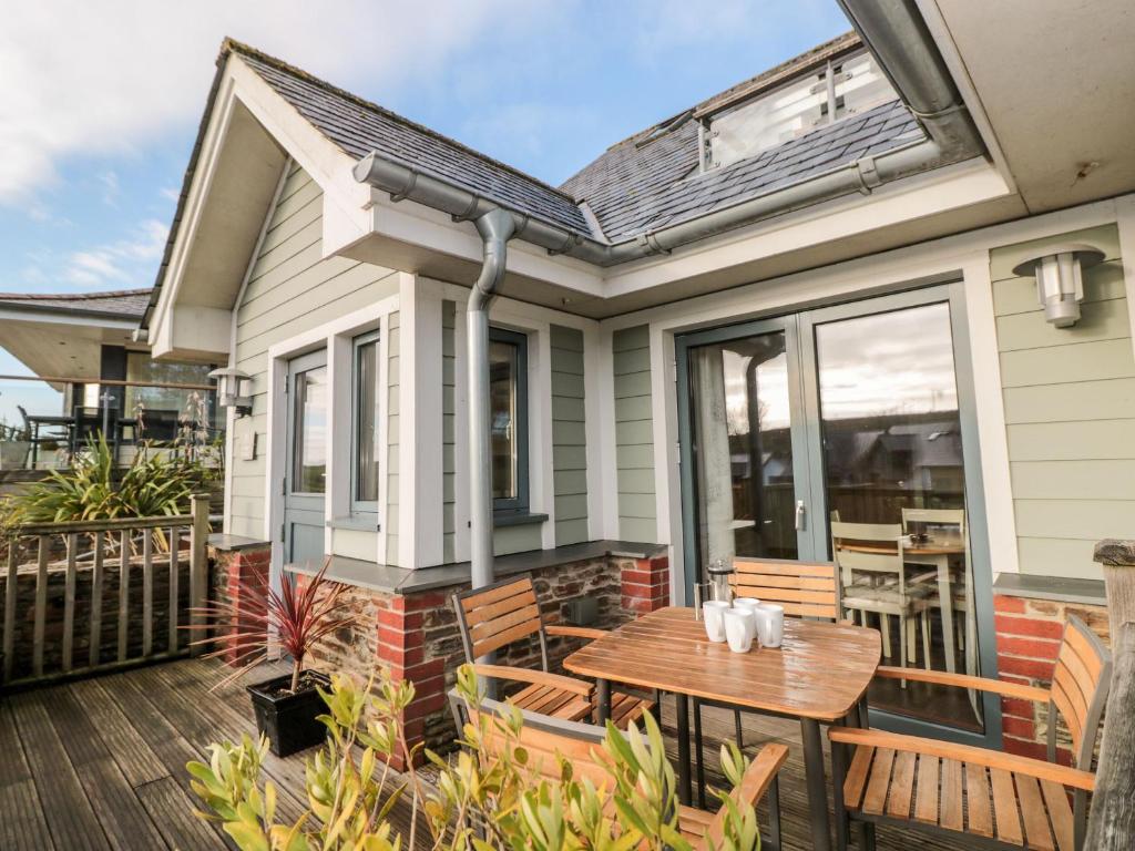 Un patio con una mesa y sillas en una casa. en 1 Court Cottage, Hillfield Village, en Dartmouth