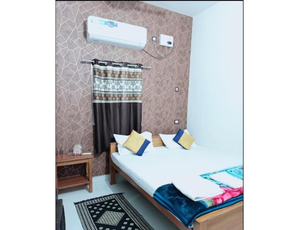 Hotel Modern Palace, Muzaffarpur في مظفربور: غرفه فندقيه بسرير ونافذه