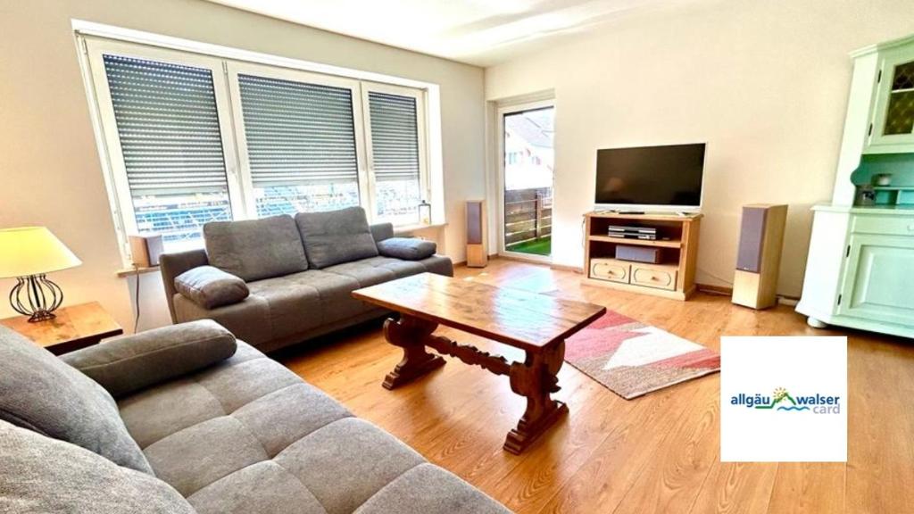 a living room with a couch and a table at FeWo Bergliebe, Oberstaufen-Wiedemannsdorf in Oberreute