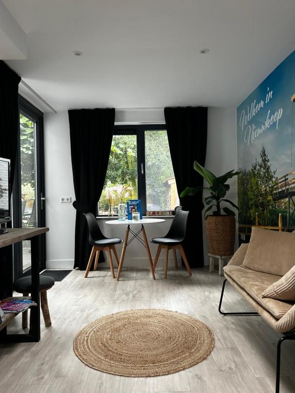 Casa aan de Plas, B&B met sauna en hottub of jacuzzi في Nieuwkoop: غرفة معيشة مع طاولة وكراسي