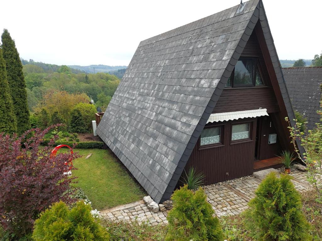 a house with a grey roof with a garden at Haus am See Willingen in Willingen