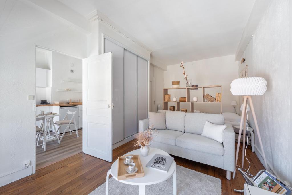 un salon avec un canapé blanc et une table dans l'établissement Angelina - Proche de la Place Bellecour, à Lyon