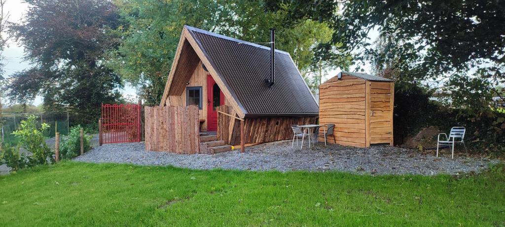 a small wooden cabin with a table and chairs in a yard at Glasson Glamping Farm in Athlone