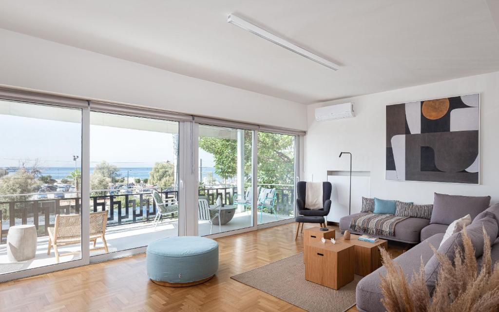 ein Wohnzimmer mit einem Sofa und einem großen Fenster in der Unterkunft Glyfada Unique Residence in Athen