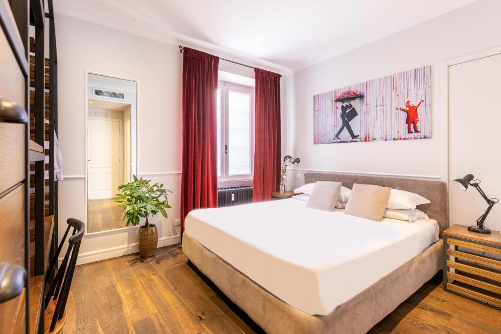 a bedroom with a large white bed and a window at Alla Corte Guest House in Rome