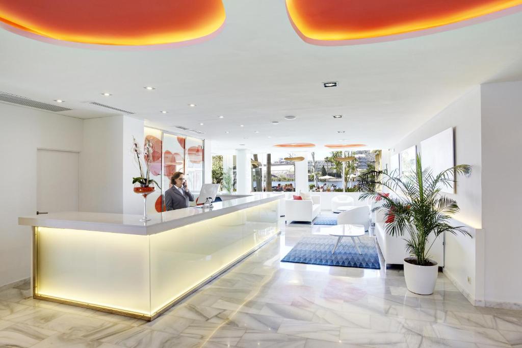 an office lobby with a woman working at a desk at Grupotel Amapola in Playa de Muro