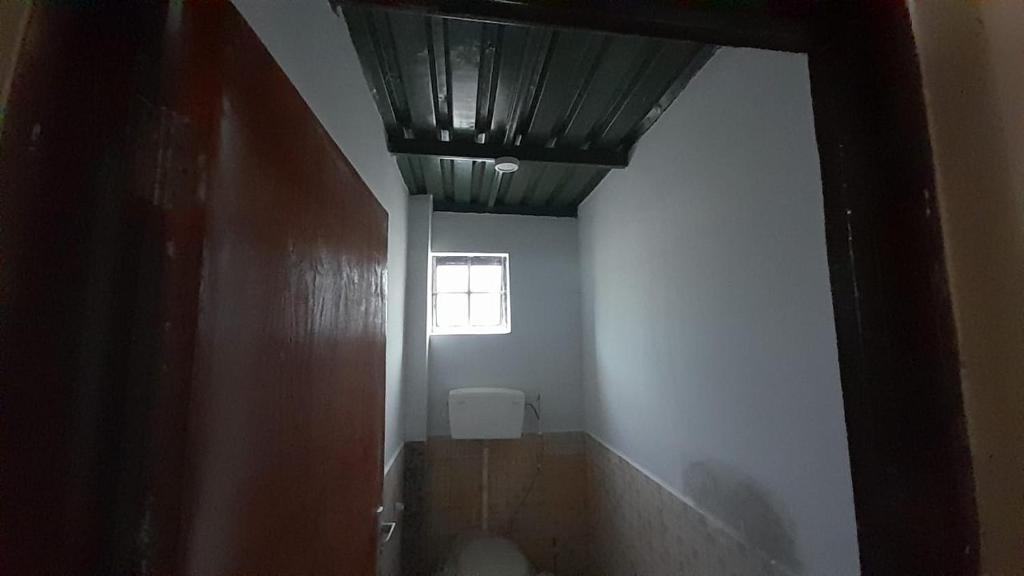 un corridoio di un bagno con finestra e soffitto di The Warehouse a Kitengela 