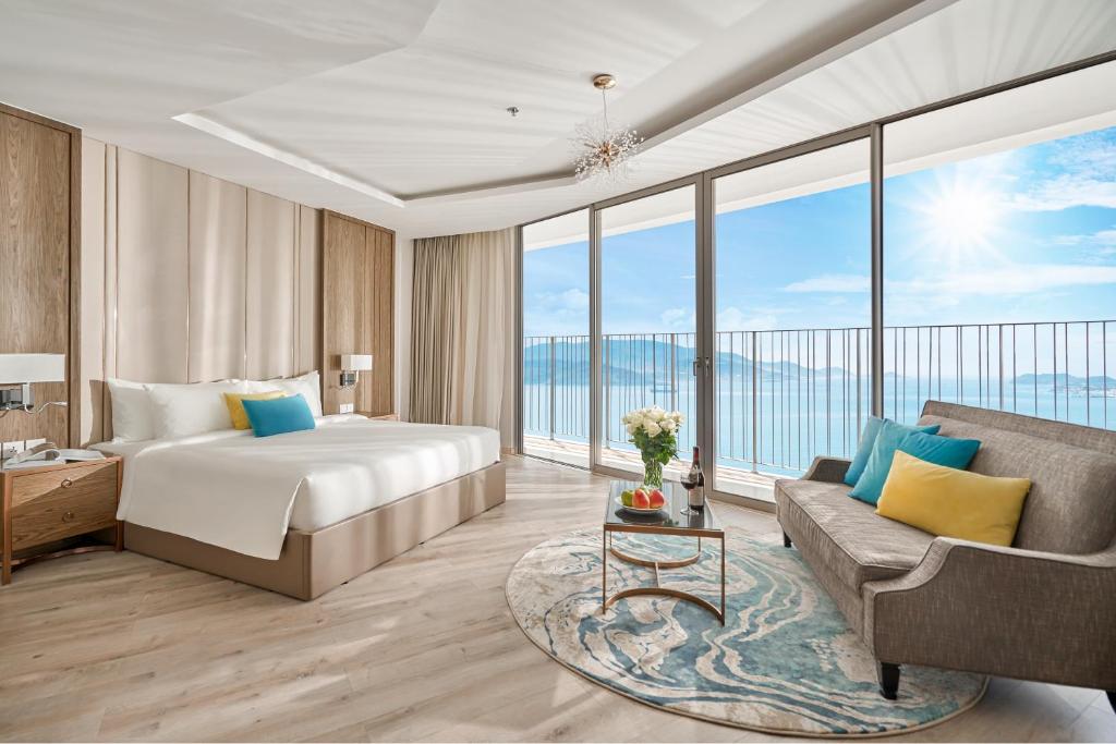 a hotel room with a bed and a couch at Capital Beachfront Nha Trang in Nha Trang