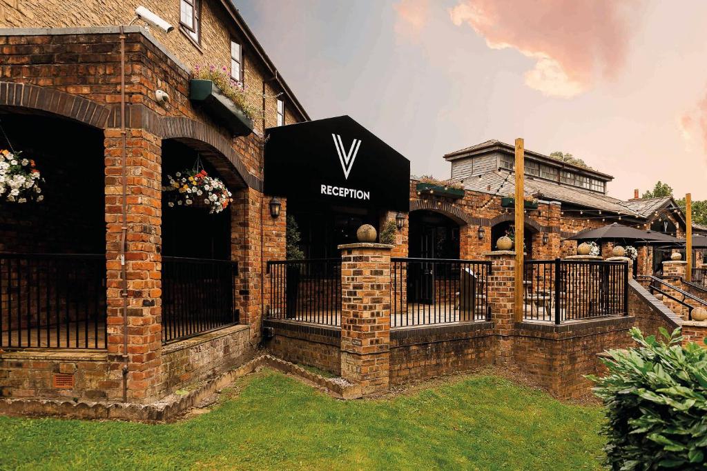 um edifício de tijolos com um sinal de verizon em Village Hotel Liverpool em Prescot