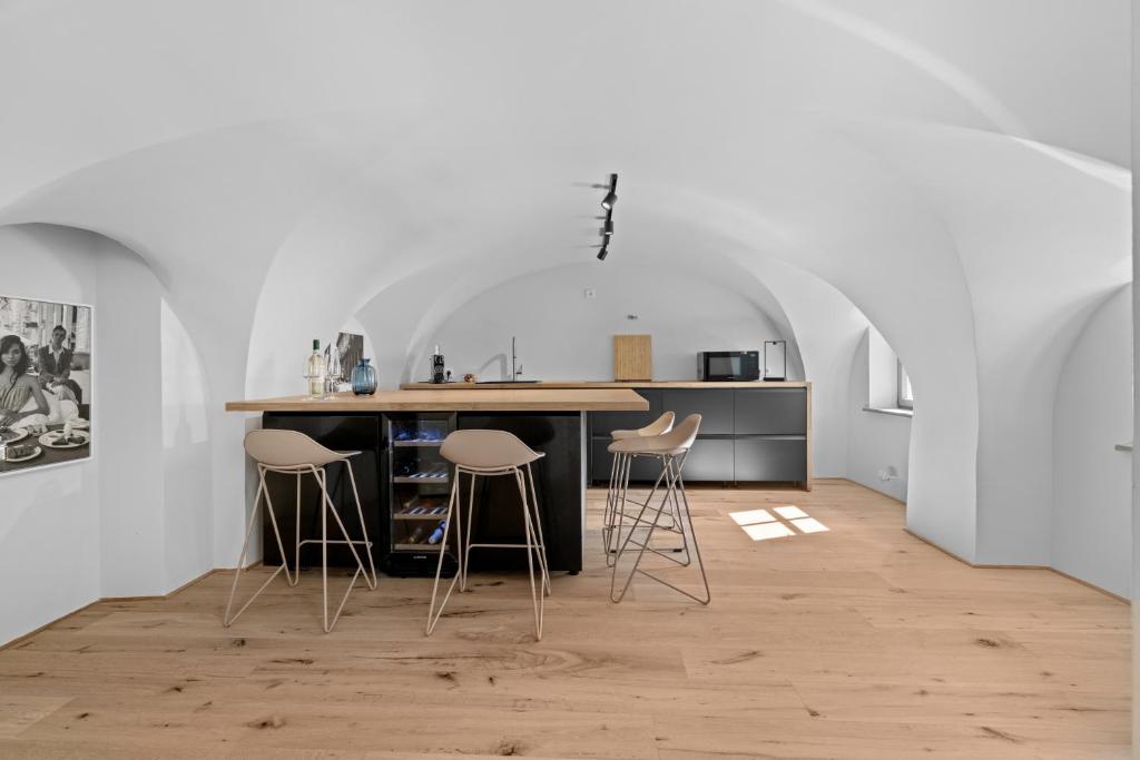 a kitchen with a counter and stools in a room at Innenstadt- Parken- Nähe Rathaus in Augsburg