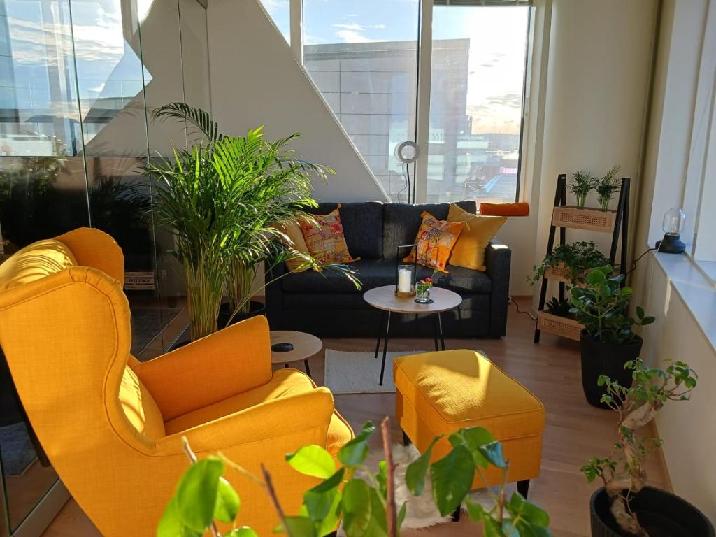 - un salon avec des chaises orange et un canapé dans l'établissement Huoneisto Nokia Areenan yhteydessä, à Tampere